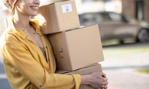 Woman carrying cardboard boxes